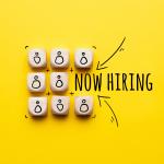 Now hiring (Graphic showing abstract staff icons on dice.)