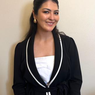 An image of Sarah Algashgari wearing a black blazer 