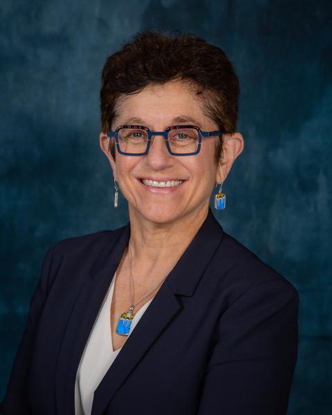 headshot of a bespeckled woman in suit